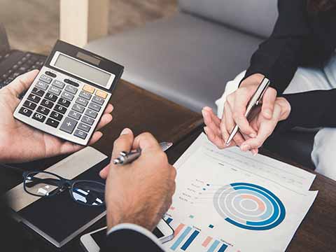 two-workers-with-a-calculator-and-stack-of-papers