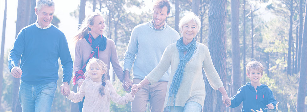 family-with-two-small-children-and-grandparents-holding-hands-walking-and-smiling